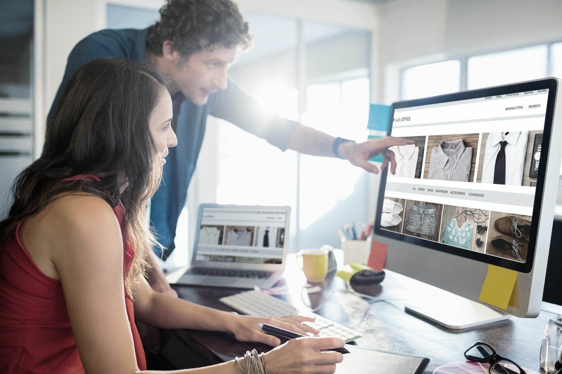 Man and woman looking at clothes on the computer while online shopping.