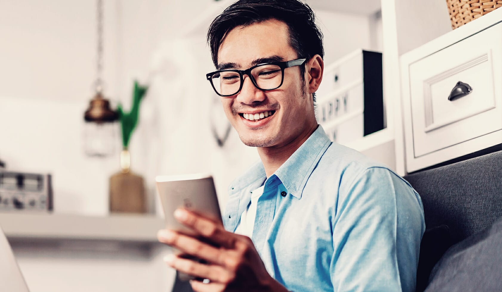 Man smiling at his phone while discovering new products while online shopping.