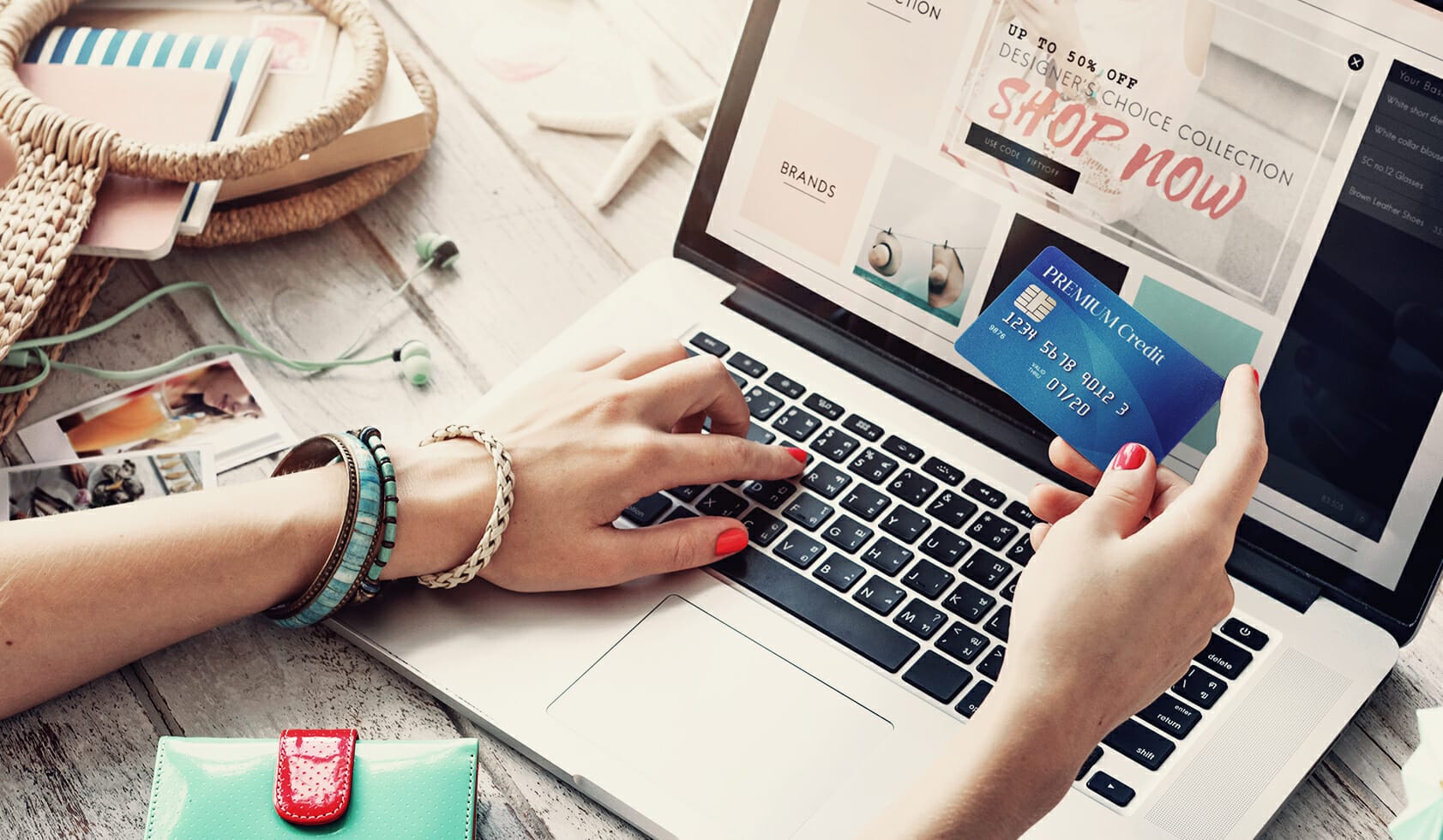 Woman holding a credit card while online shopping for fashion products.